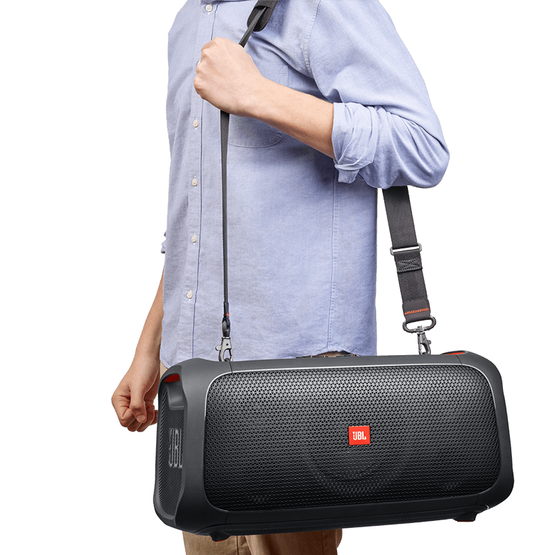 JBL Partybox On The Go (OTG) with a guy using the shoulder straps Photo